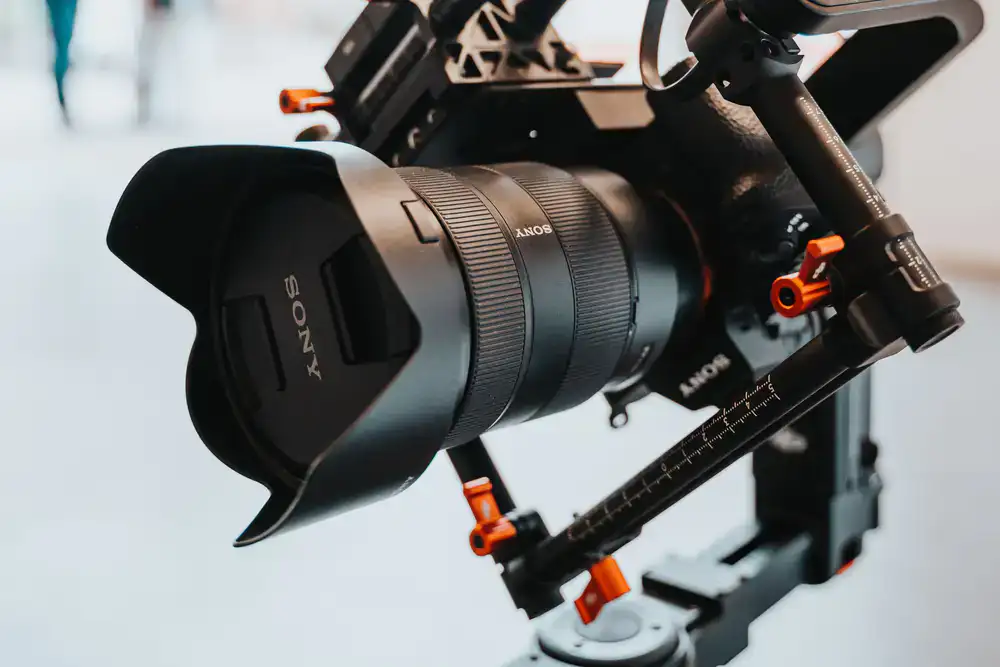Close-up of a professional mirrorless camera mounted on a desk arm